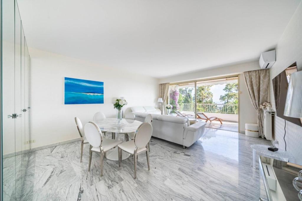 un salon avec une table et un canapé dans l'établissement Bright one-bedroom in a quiet area wswimming pool, à Cannes