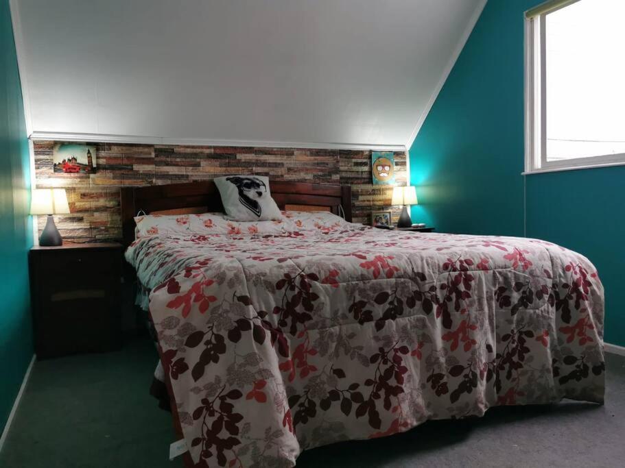 una camera da letto con un grande letto con una coperta rossa e bianca di Alojamiento Casa completa en Puerto Montt a Puerto Montt