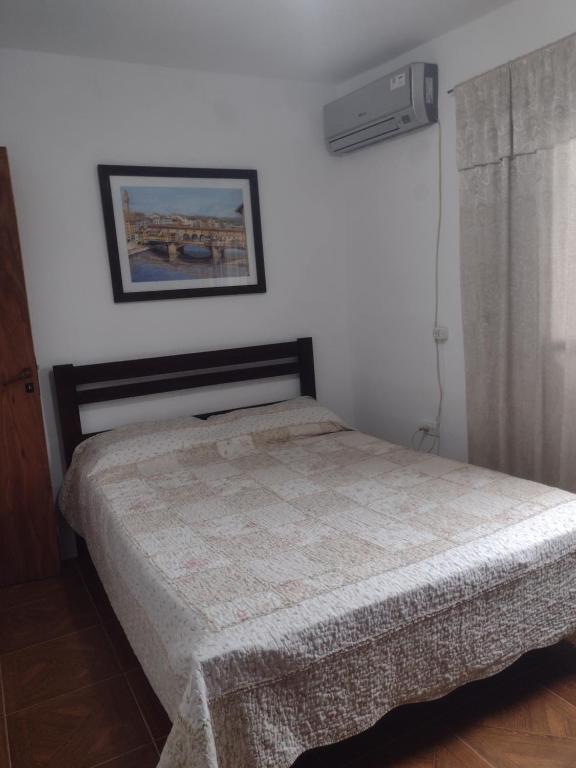 sypialnia z łóżkiem i zdjęciem na ścianie w obiekcie Departamento temporario en cordoba w Córdobie