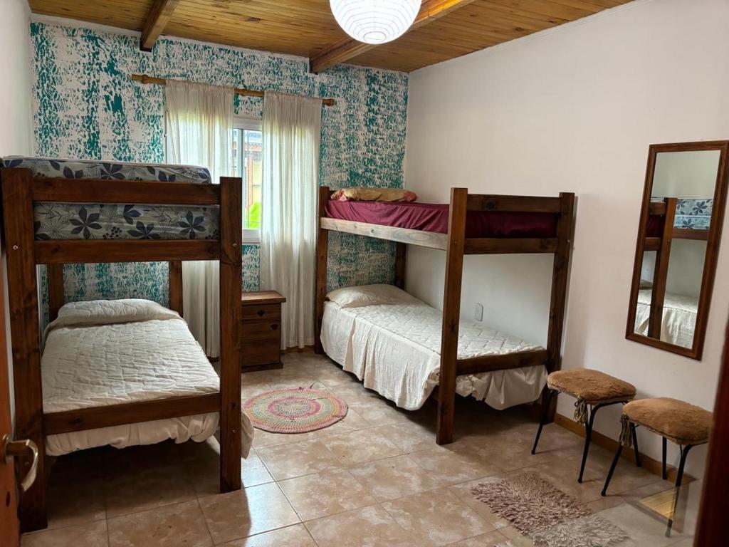 1 dormitorio con 2 literas y espejo en Lothbrok House en Villa Rumipal