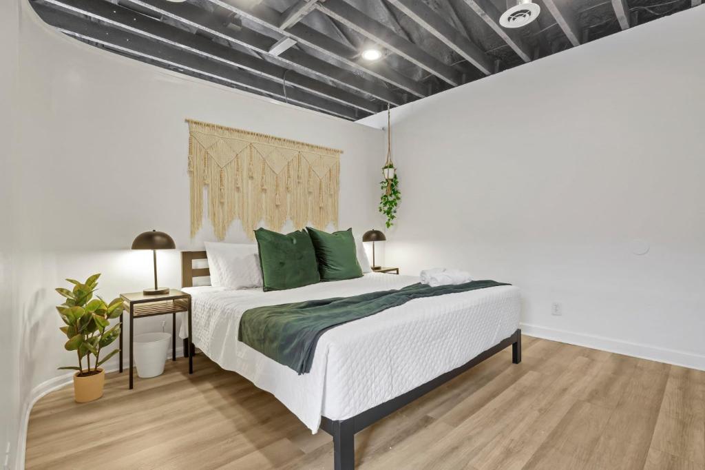 1 dormitorio con cama blanca y almohadas verdes en Housepitality - The City View Suite, en Columbus