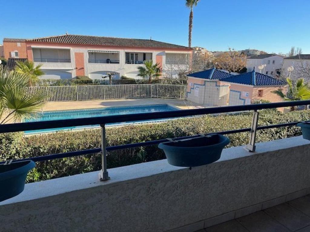 un balcon avec 3 pots bleus sur une balustrade dans l'établissement Appartement T2 avec Terrasse, Parking Privé et Piscine Sécurisée, Proche Plage Richelieu - FR-1-749-37, au Cap d'Agde