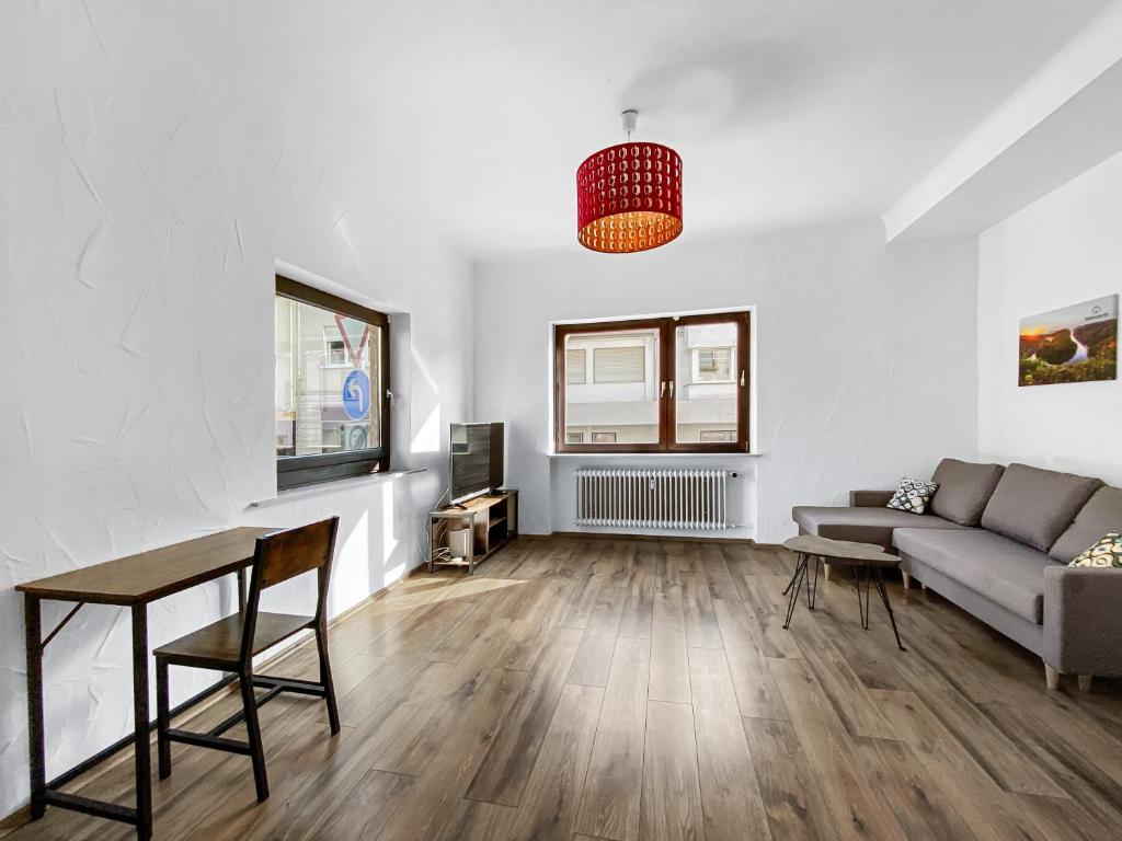 ein Wohnzimmer mit einem Sofa und einem Tisch in der Unterkunft CityChalet Monteur Apartments in Saarbrücken