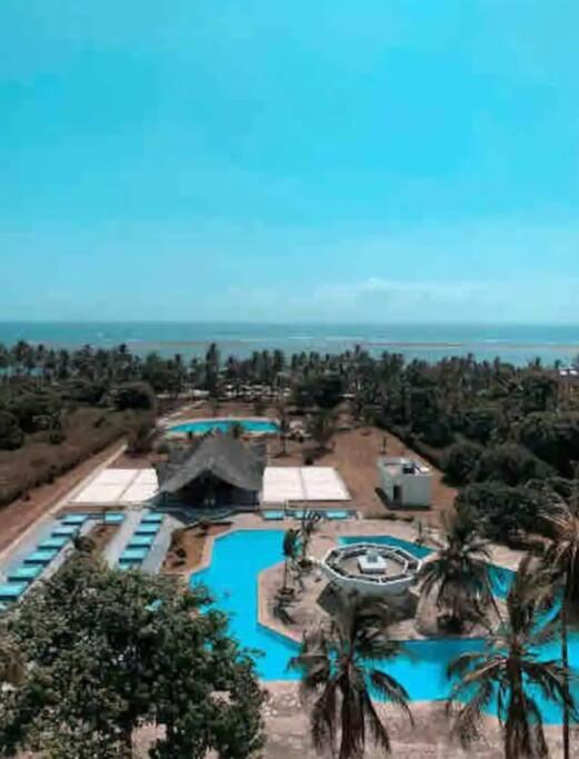 an aerial view of a resort with a swimming pool at Restful Beach Front studio-Diani in Diani Beach