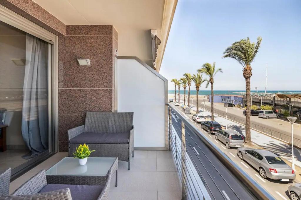 einen Balkon mit Blick auf den Strand und die Palmen in der Unterkunft Apartamento frente al mar in Benicarló