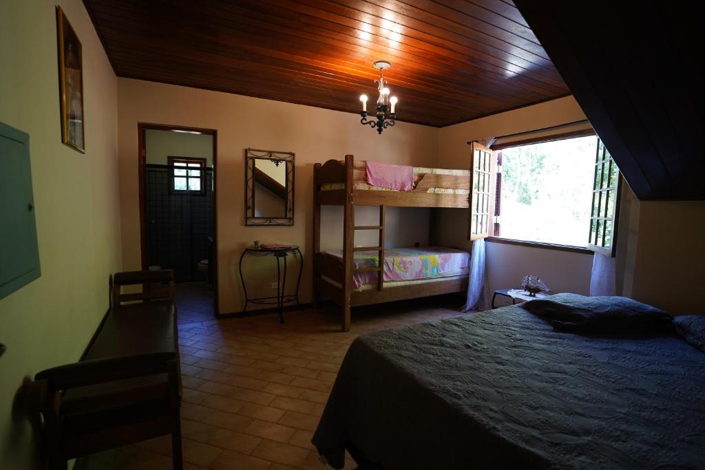 ein Schlafzimmer mit zwei Etagenbetten und einem Fenster in der Unterkunft Sitio Recanto Feliz na Estrada do Vinho km 4,5 - Sao Roque in São Roque