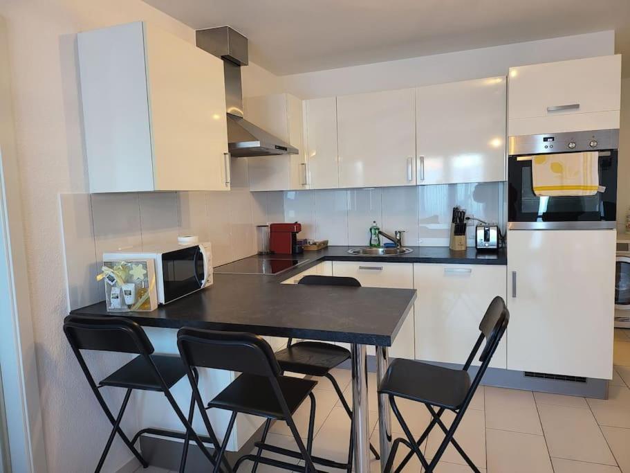 una cocina con mesa negra y 4 sillas en appartement cosy en Tafers