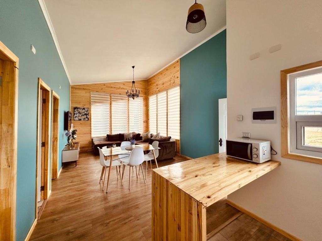 cocina y sala de estar con mesa y sofá en Cabañas Arte Brisa Patagonia en Puerto Natales