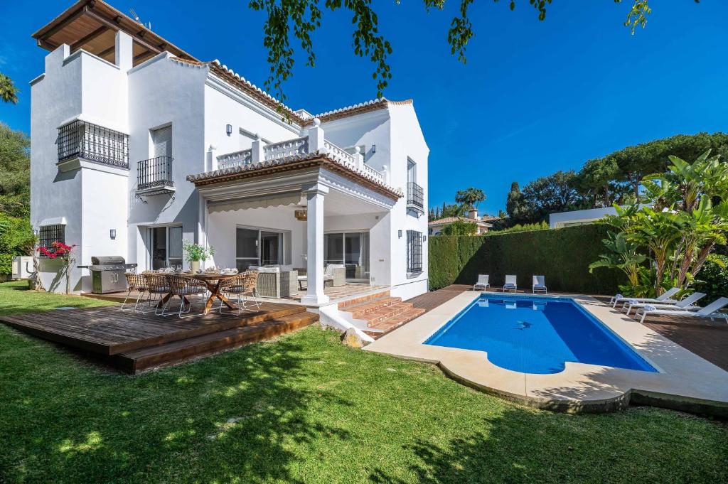 una casa bianca con piscina nel cortile di VACATION MARBELLA I Villa Nadal, Private Pool, Lush Garden, Best Beaches at Your Doorstep a Marbella