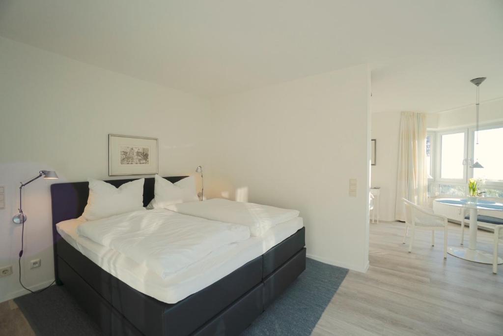 1 dormitorio con 1 cama grande con sábanas blancas en Ferienwohnung Strandhüpfer - direkt am Meer, en Eckernförde