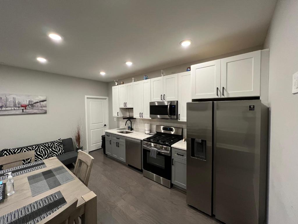 a kitchen with stainless steel appliances and white cabinets at Charming 3BR 2BA with Private Patio in Philadelphia