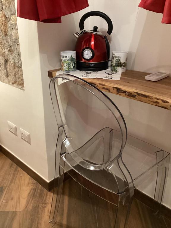 a clear chair sitting under a counter with a tea kettle at Bretone XI b&b in Rome