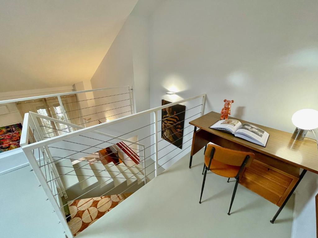 a room with a staircase with a desk and a table at 149 BORGO TICINO SUITE Attico di Lusso con Terrazzo e Parking Privato in Pavia