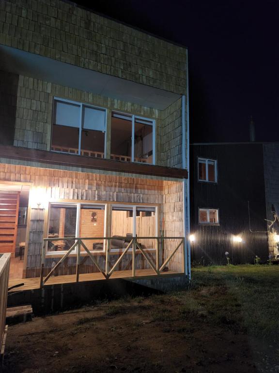 un edificio de ladrillo con porche por la noche en Cabaña Loft del Sur Premium, en Chonchi