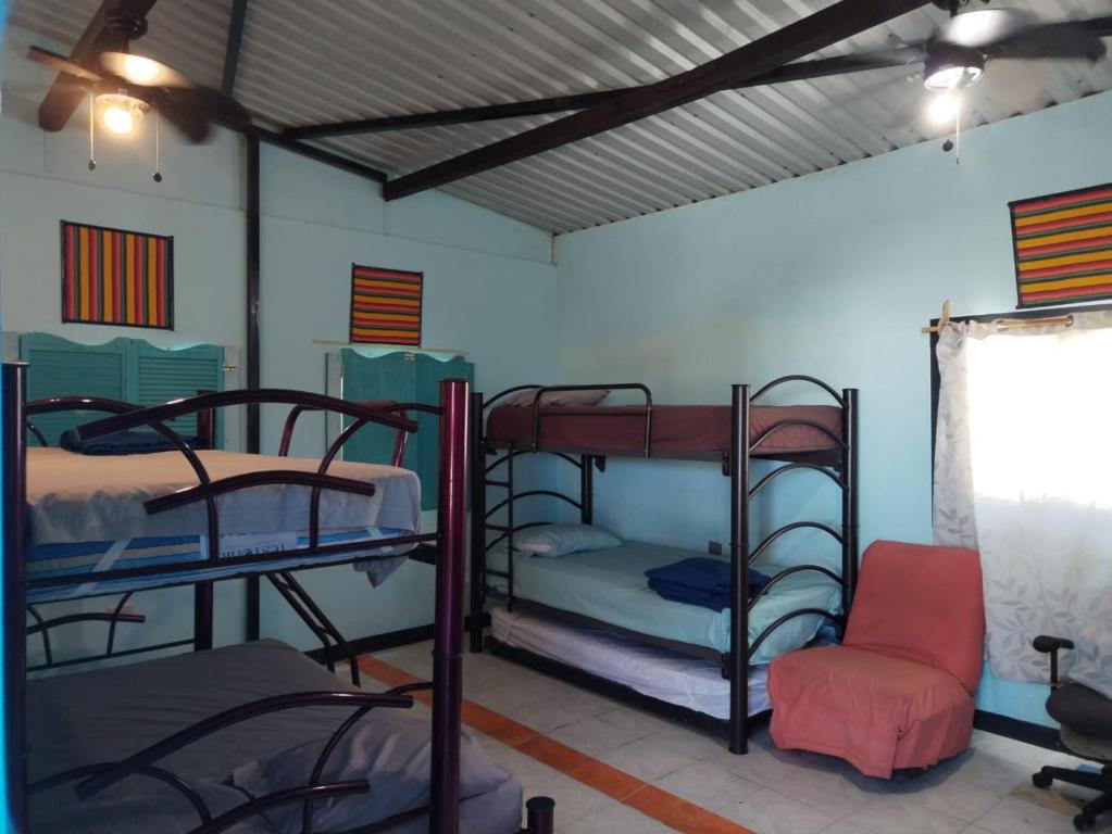 a room with three bunk beds and a chair at Posada Boutique in Cancún