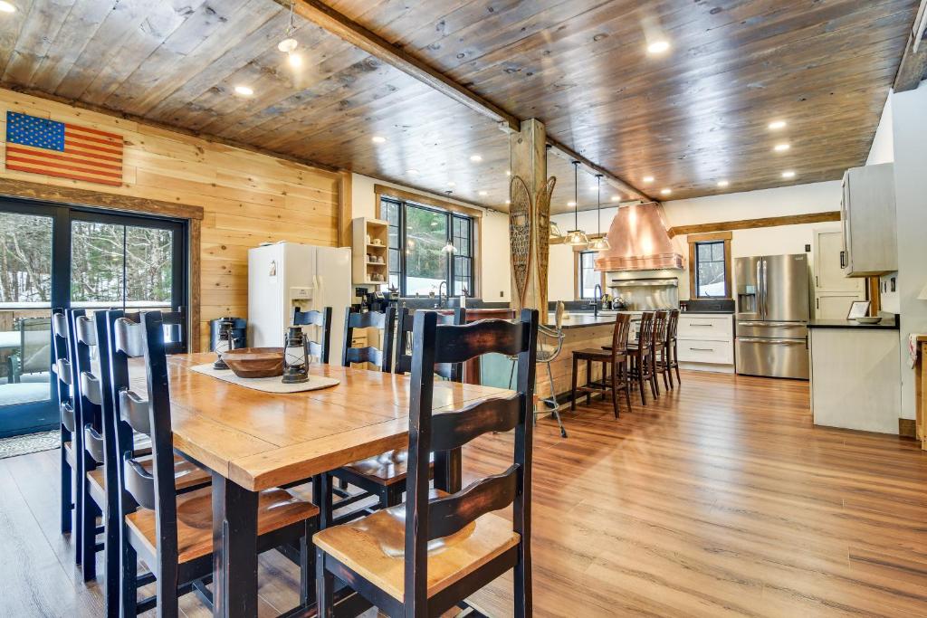 a kitchen and dining room with a wooden table at Maine Home with Private Hot Tub and ATV Trail Access! 