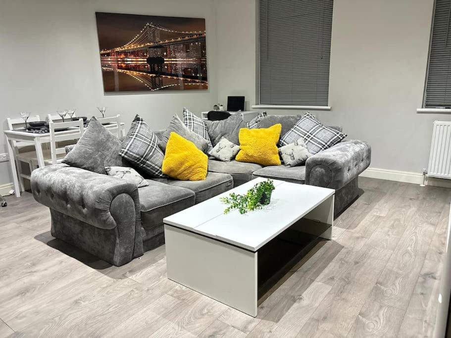 a living room with a couch and a table at Luxury apartment in Slough FREE Parking near Heathrow, Legoland & Windsor Castle in Slough