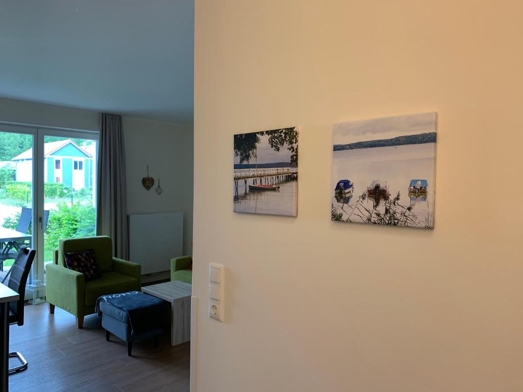 a living room with three pictures on the wall at Hafendorf Haus 5_ Apartment 3 in Plau am See