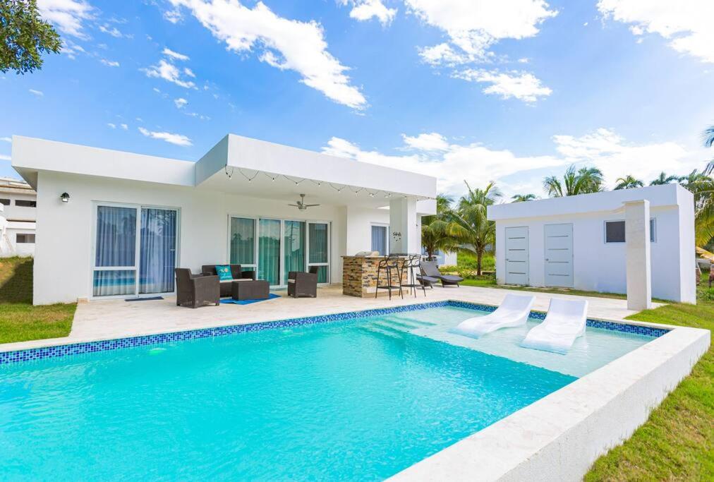 a villa with a swimming pool in front of a house at Villa Cancu, 2 bd, 2.5 bath, wi-fi, pool, Parking in Cabarete