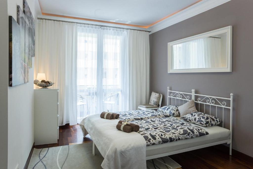 a bedroom with a bed and a large window at MW Apartmenty - Abrahama in Gdynia