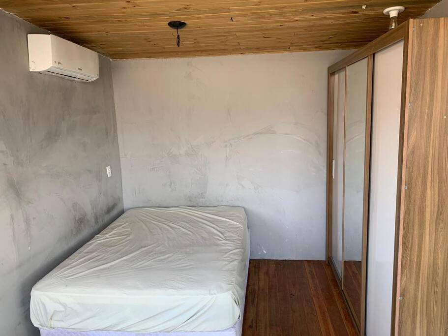 ein kleines Schlafzimmer mit einem weißen Bett darin in der Unterkunft Loft com Hidro no centro in Balneário Camboriú
