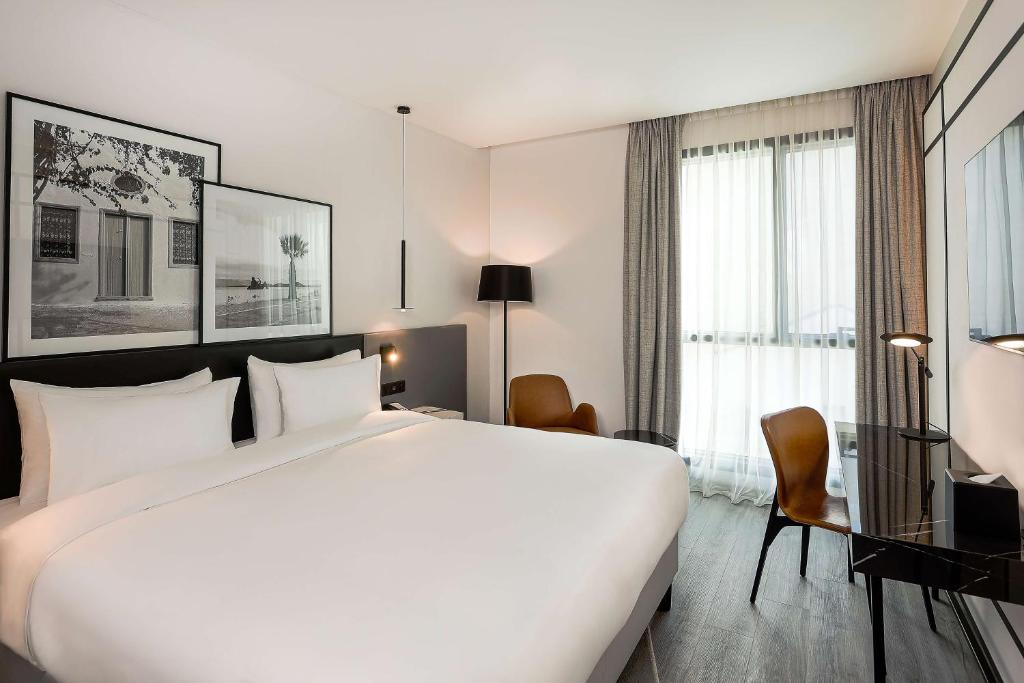 1 cama blanca grande en una habitación de hotel en Radisson Hotel Tunis, City Center, en Túnez