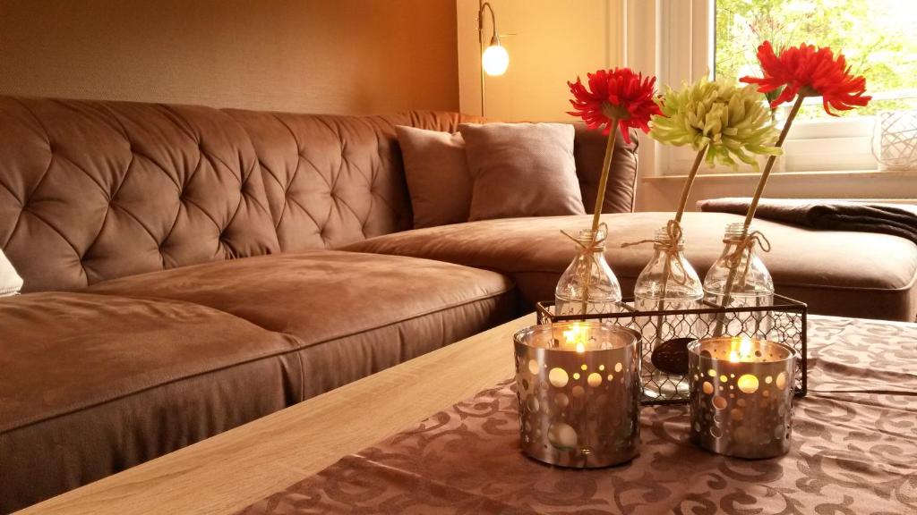 ein Wohnzimmer mit einem Sofa und einem Tisch mit Kerzen in der Unterkunft Ole's BergSuite in Braunlage
