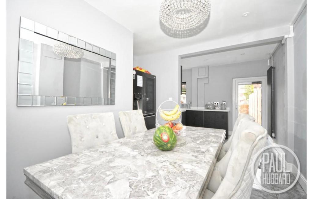 a dining room with a table and chairs and a kitchen at Modern three bed house in Ditchingham