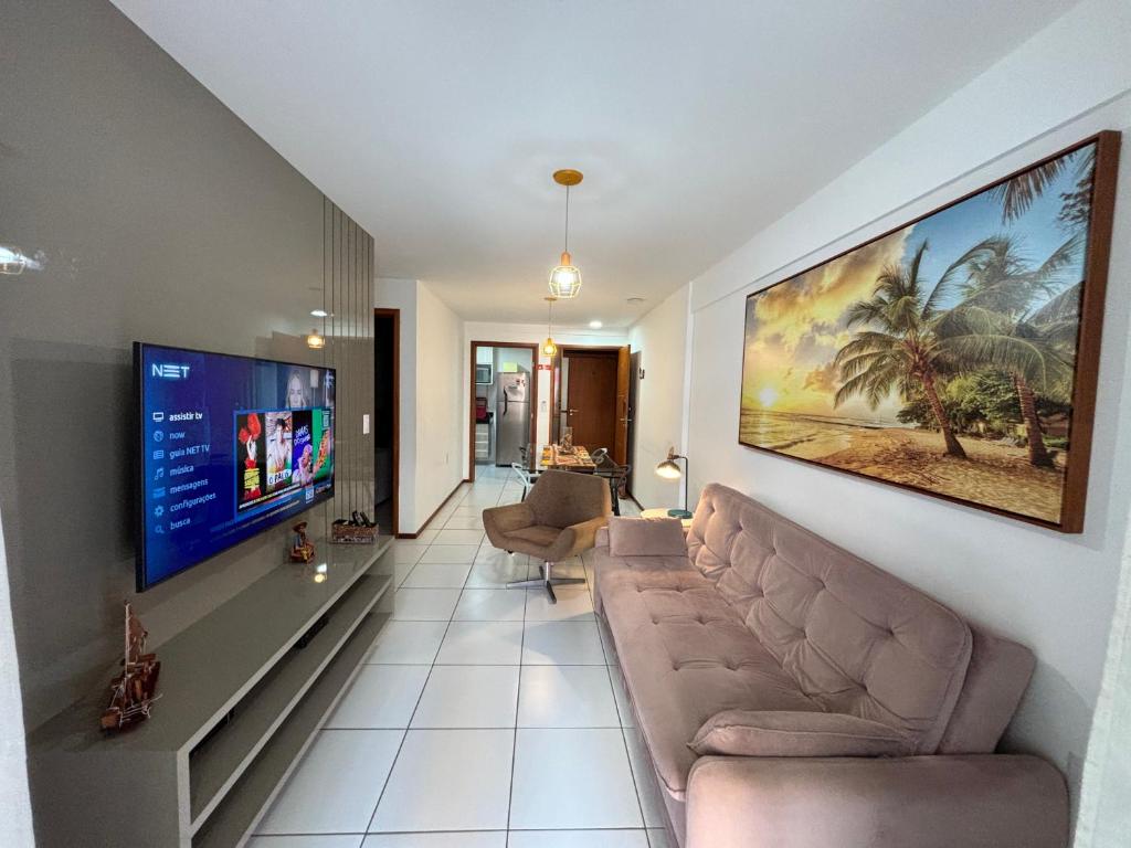 a living room with a couch and a flat screen tv at Apartamentos 250m da Orla -Edifício Nugali- Castelo B Temporada in Maceió