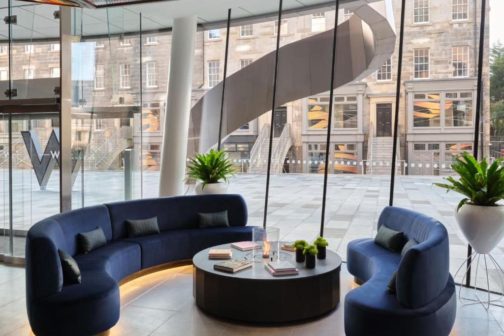 a lobby with two blue couches and a table at W Edinburgh in Edinburgh