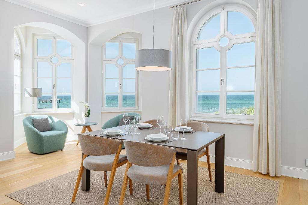 a dining room with a table and chairs and the ocean at Villa Schwan Wohnung 03 in Heiligendamm