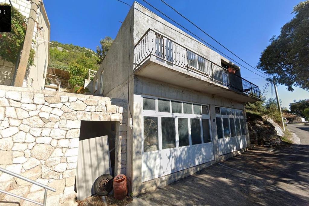 an old stone building with a balcony and a fire hydrant at Apartments with parking spaces Babino Polje, Mljet - 22321 in Babino Polje