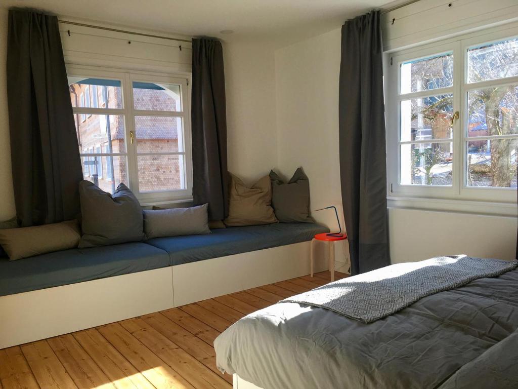 上斯陶芬的住宿－Rosinas - Alte Küche，卧室在两扇窗户前设有蓝色长椅