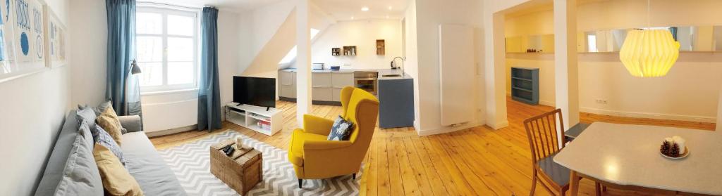 a living room with a table and a yellow chair at Rosinas - Fräulein Thäsler in Oberstaufen