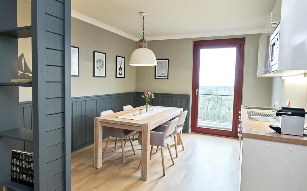 eine Küche und ein Esszimmer mit einem Tisch und Stühlen in der Unterkunft Apartement Jasmund mit Ostseeblick - Haus Fore zu Schloss Ranzow in Lohme