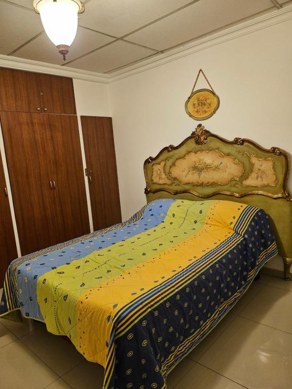 a bedroom with a bed with a comforter on it at Apartaments Malecon 2000 in Guayaquil