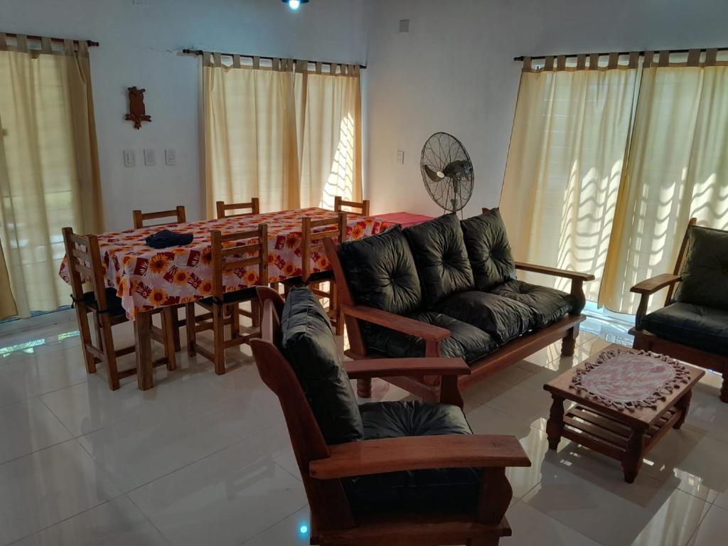 un salon avec un canapé, une table et des chaises dans l'établissement Casa de descanso y naturaleza, à Paso de la Patria