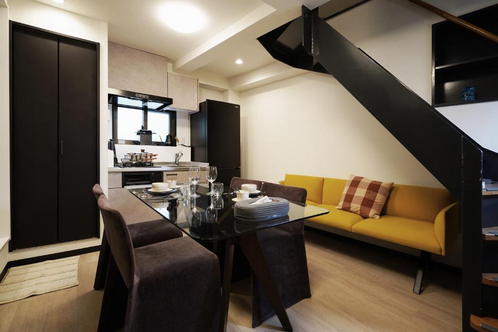 jadalnia ze stołem i żółtą kanapą w obiekcie Penthouse 1-bedroom flat in Hiroo Shibuya w Tokio