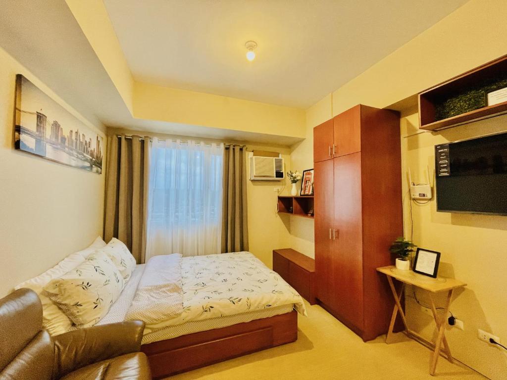 a small room with a bed and a couch at City View Studio Unit at Aspira Tower 1 in Cagayan de Oro