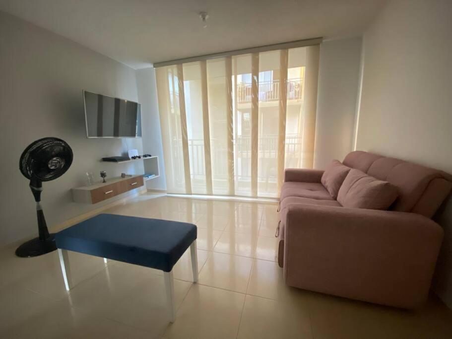 un soggiorno con un divano e un tavolo di Apartamento completo con aire en Valledupar a Valledupar