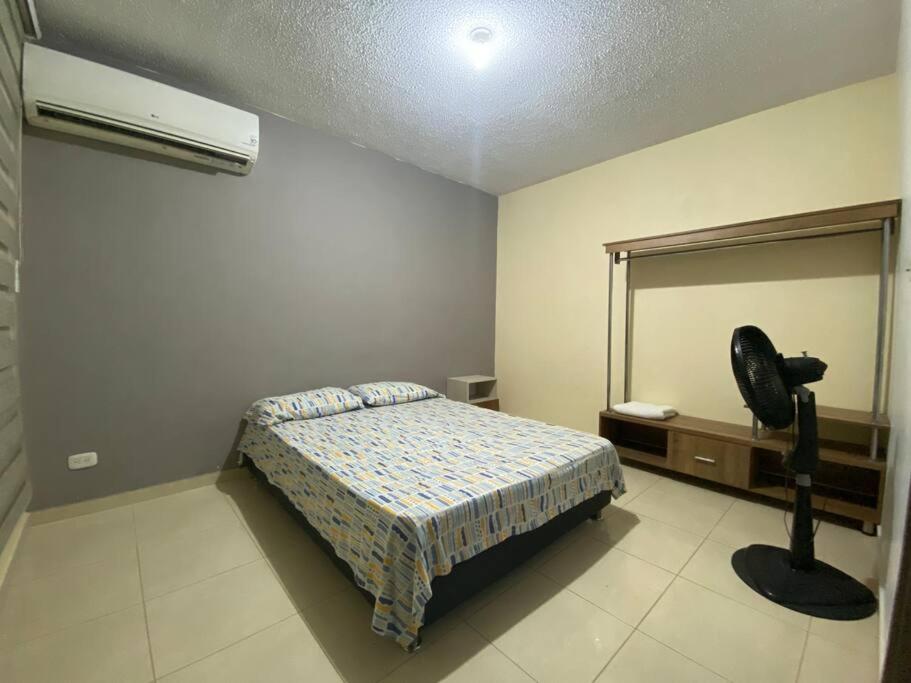 una camera con letto, specchio e ventilatore di Apartamento completo con aire en Valledupar a Valledupar