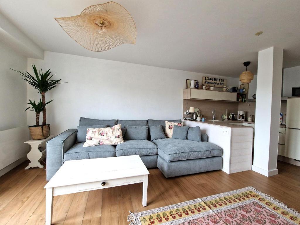 un salon avec un canapé bleu et une table dans l'établissement Apartment in Bénodet near Sandy Beaches, à Bénodet