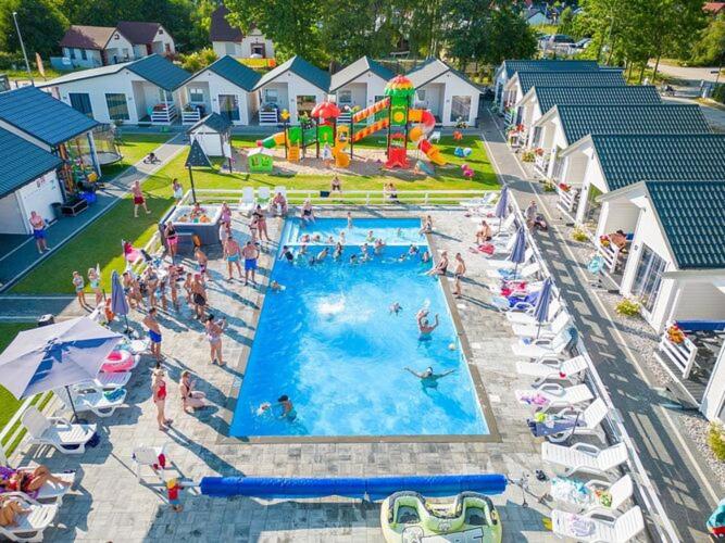un grupo de personas en una piscina en un complejo en Holiday cottages, pool, whirlpool, D bki, en Dąbki