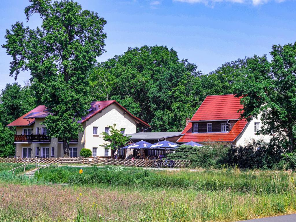 a house with a red roof next to two buildings at Friendly apartment in Lübben an der Spree in Lübben