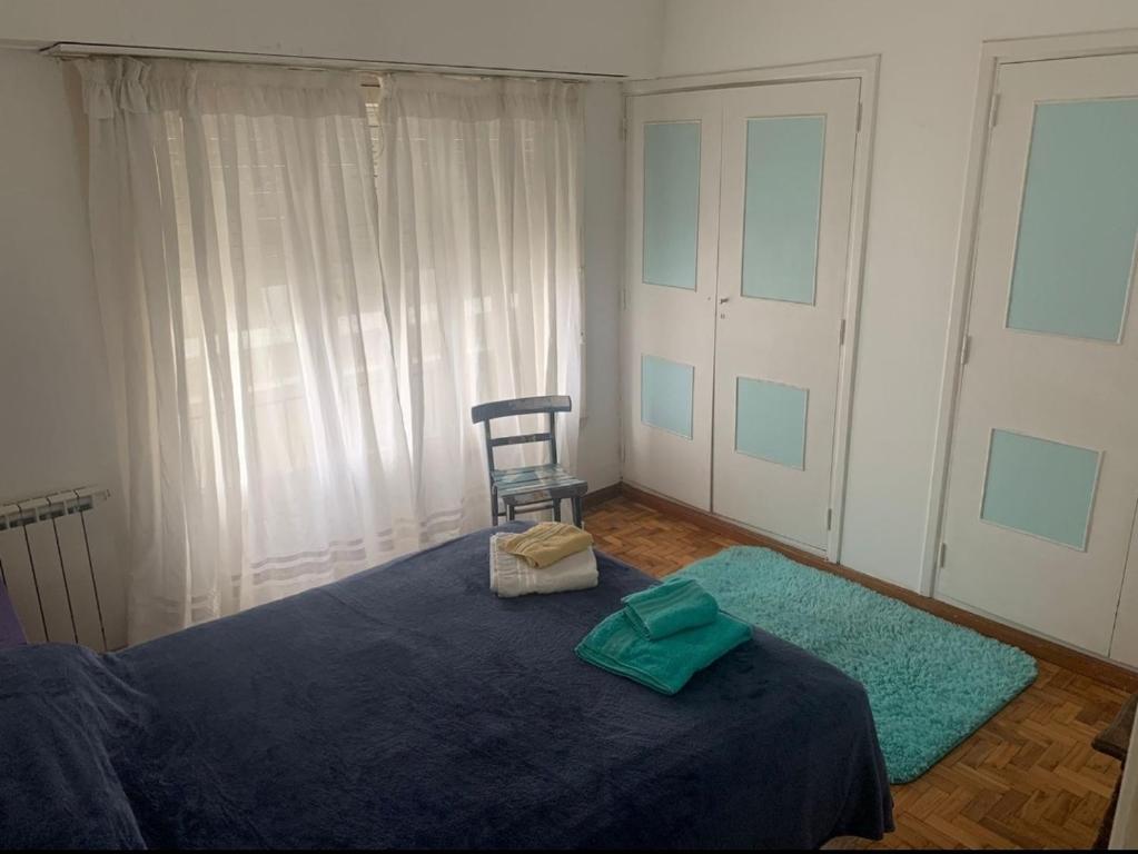 ein Schlafzimmer mit einem blauen Bett und einem Stuhl in der Unterkunft Playa Grande in Mar del Plata