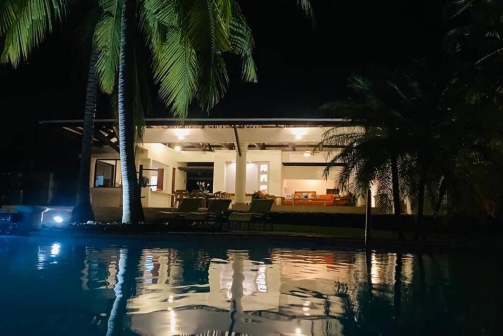 una casa con piscina por la noche en Casa Don Willo, en Escuintla