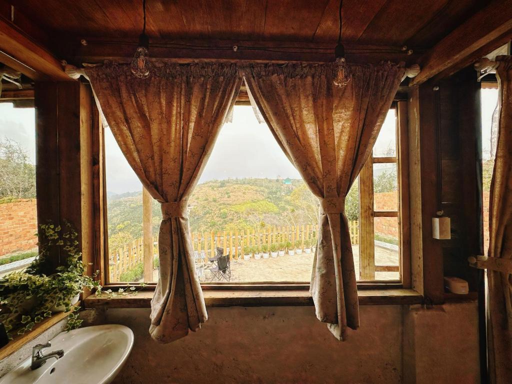 a bathroom with a sink and a window with a view at Homestay KV Houses - Cầu Đất in Xuân Trường