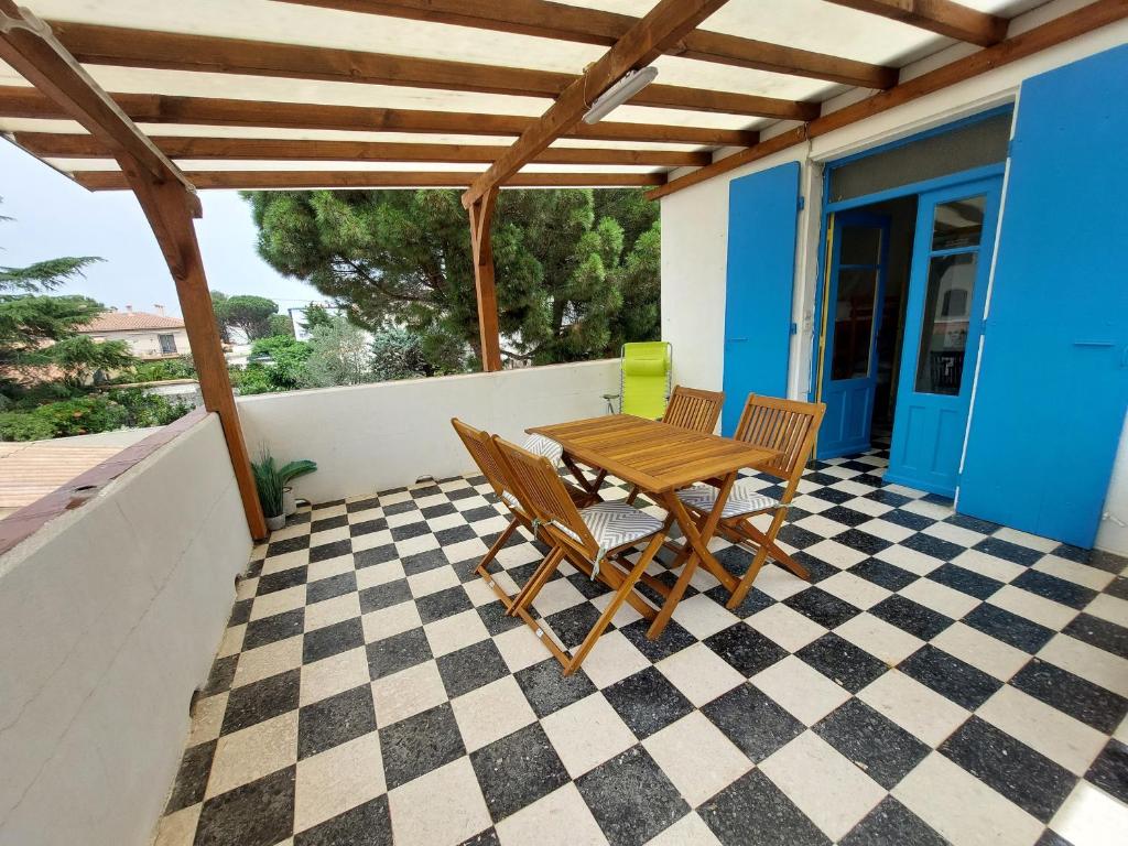 d'une terrasse sur le toit avec une table et des chaises en bois. dans l'établissement Appartement 4 pers à 50m de la plage avec terrasse calme et proche commerces à Argelès-sur-Mer - FR-1-776-51, à Argelès-sur-Mer