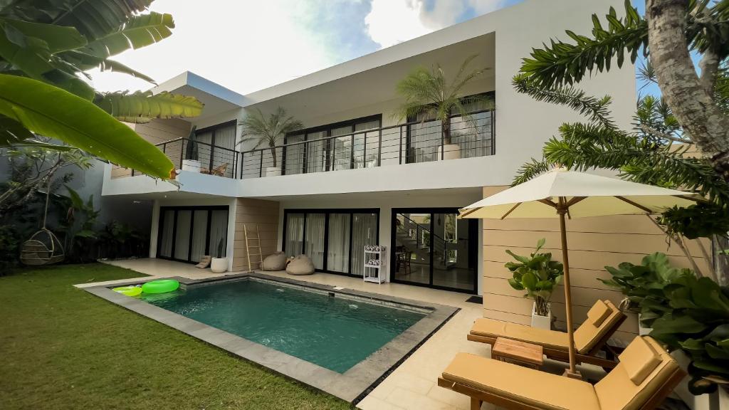 a house with a swimming pool in front of it at Admire Villa - a luxury private villa with Pool in Legian