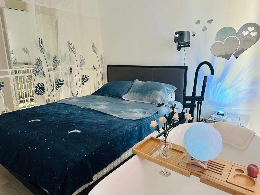 - une chambre avec un lit avec des draps bleus et une table dans l'établissement Laguna Beach Resort 2-have tub loft room, à Jomtien Beach